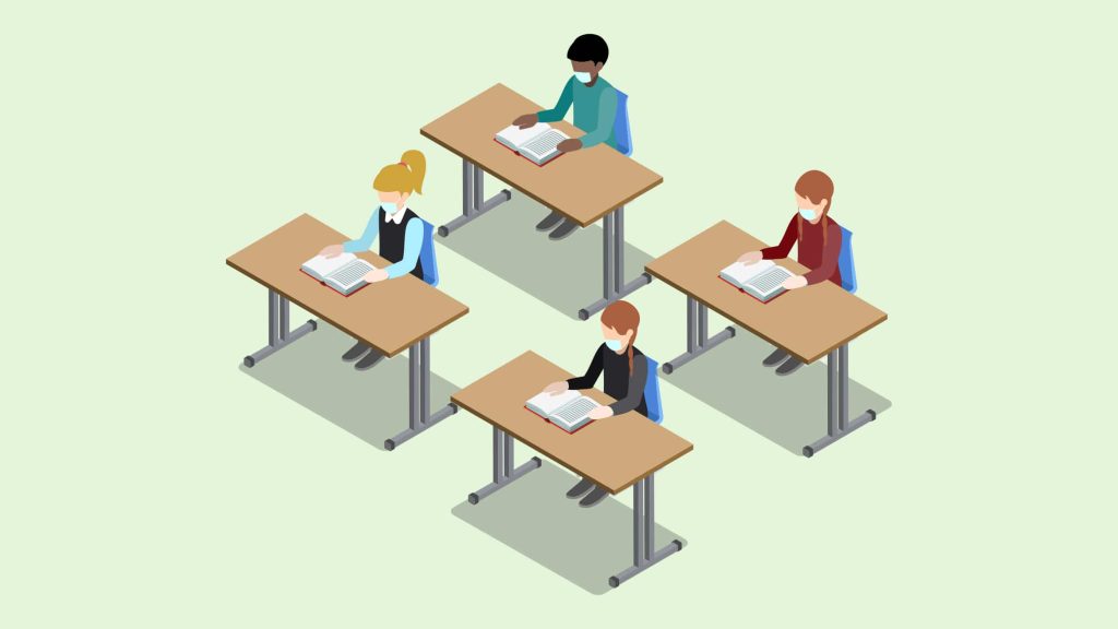 3 female students and one dark skinned male student at school tables wearing mask.